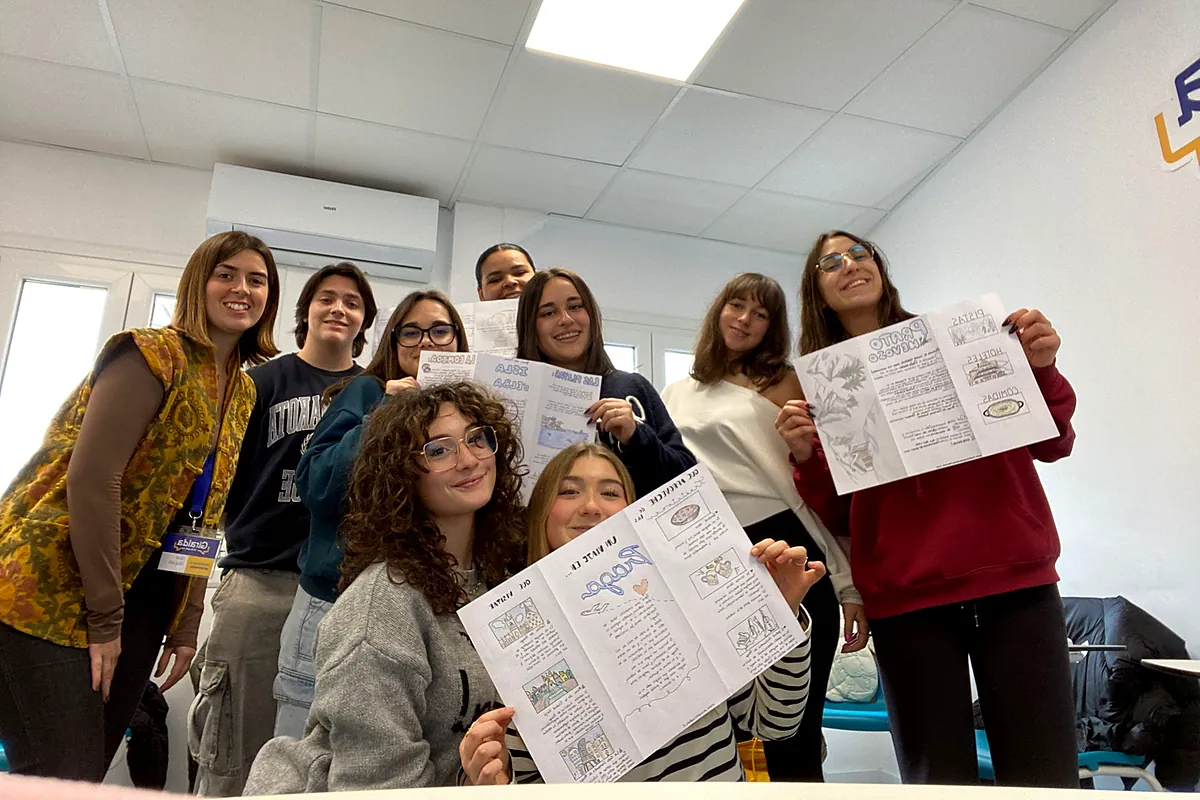 Estudiantes muestran los folletos creados en un taller en el aula de Giralda In&Out