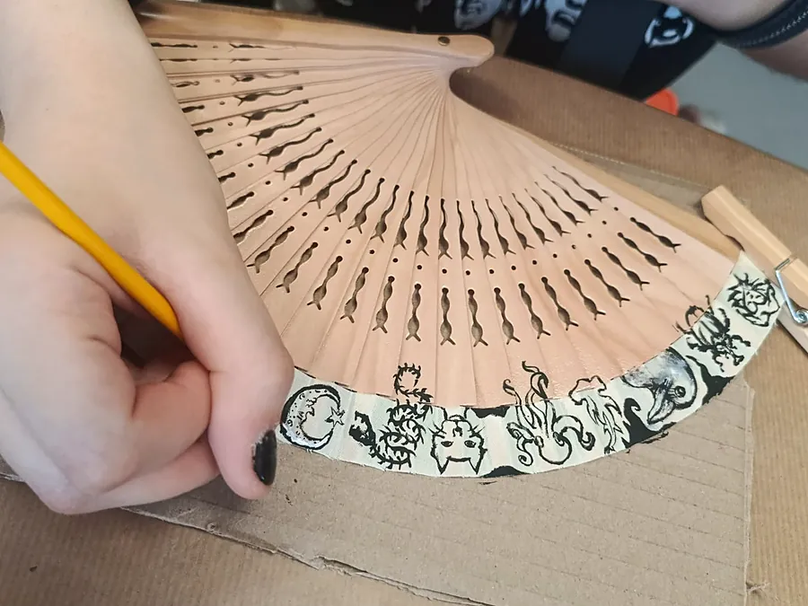 Estudiante decorando un abanico en el taller de abanicos