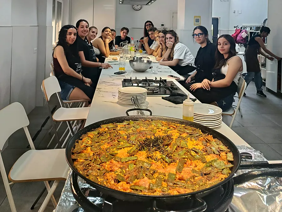 Grupo de estudiantes en la mesa con su paella