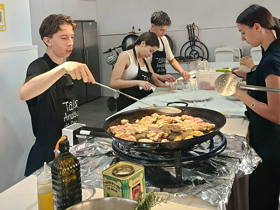 Estudiantes cocinan una paella